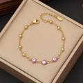 Dettaglio del bracciale a sfere in oro 18K con ciondoli occhio viola su scatola in pelle - Viola