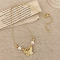 Elegante collana a farfalla dorata con perle di rame e perle su tessuto strutturato - Collana di Perle Con Farfalla Dorata / Oro