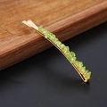 Detailed close-up of green crystal stones on a gold-plated minimalist hair clip - Peridot Gold