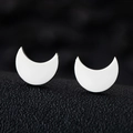 Macro view of polished silver crescent moon stud earrings on a textured black background - Moon / Silver