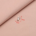 Detailed view of silver stainless steel cord ends with 3mm x 6mm dimensions on pink cloth - Style 4 (3x6mm)