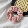 Close-up of pink knitted velvet scrunchie showing fine ribbed texture on white fabric - Corduroy / Pink