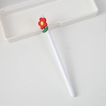 Cartoon gel pen with white barrel and red flower topper on a white desk - Flower