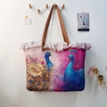 Detail of bohemian canvas tote with peacock print, white tassels, and leather handles - Artistic Peacock Print