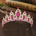 Macro detail of golden baroque crown with pink teardrop crystals on vintage book background - Gold + Rose Red Rhinestone