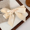 Close-up of a beige satin bow hair clip on a vintage decorative background - Hair Bow / Beige