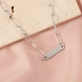 Detail of silver bar pendant on paperclip chain over pink silk and beige stone - Steel Color + 1 Accessory