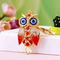Golden owl keychain with blue evil eyes and red enamel detail on a white gift box - A430 Owl I Red