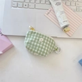Gros plan d'une pochette à carreaux verts avec broderie florale et pendentif perle - Carreaux verts