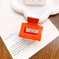 Minimalist bright orange hollow rectangular acetate hair claw clip on vintage newspaper - Vitality Orange