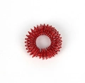 Detail of a red metallic spring finger massage ring for acupressure therapy - Red