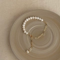 Close-up of Baroque pearl bracelet with gold metal chain links and lobster clasp on ceramic - Splicing Freshwater Pearl Bracelet