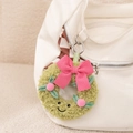 Detail of green plush wreath charm with pink bow hanging on a white canvas bag - Sweet Wreath Pendant