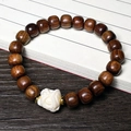 Black Rosewood bead bracelet featuring a white floral carved bead and gold accents - 8x9mm Old-Style Awakening Lion