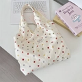 Flachbild von bunter gepunkteter Canvas-Tasche mit Laptop und Büchern auf weißem Tisch - Bunte Punkte