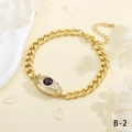 Dettaglio del bracciale a maglia cubana dorata con occhio di cristallo e gemma viola - Stile Occhio Viola (BR1818-B-2)