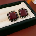 Macro shot of square vintage red fabric studs with gold border and sparkling crystals - Glossy Wine Red (Gold with Silver Needle) / Burgundy