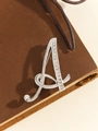 Elegant silver letter A brooch pin with sparkling rhinestones on a brown leather surface - Silver Letter A