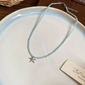 Detailed view of beaded beach necklace with starfish charm and heart glass beads in a dish - Blue Starfish Necklace
