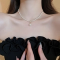 Élégant collier de perles plaqué or 18 carats avec pendentif central porté par un mannequin - Collier de perles blanc minimaliste et simple
