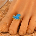 Adjustable golden octopus toe ring with blue enamel detail on beach sand - Blue Octopus (8256)