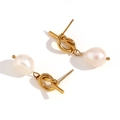 Gold plated knot earrings with baroque pearls hanging from them on white background - Knotted Button Freshwater Pearl Stud Earrings - Gold