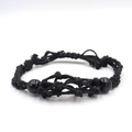 Detailed view of black handcrafted woven cord bracelet with polished beads and knots - Bracelet / Black