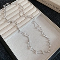 Detalle de un collar de doble capa plateado con perla de gota en bandeja de terciopelo - Collar-Plata-Blanco