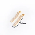 Detail of gold rectangular zircon drop earrings with size markers of 34mm by 5mm - Drop Earrings