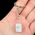 Rectangular white marble stone keychain with silver ring held by hand for size - Howlite