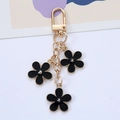 Eleganter goldener Schlüsselanhänger mit drei schwarzen Emaille-Blumen und Karabinerverschluss - Schwarz