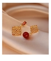 Macro shot of gold hollow flower earrings with red zircon and agate pendant details - Asymmetric Gold Hollow Flower Red Bead Style / Gold with Red