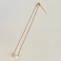 Detalle de collar de eslabones cuadrados dorados con colgante de frijol blanco - Cadena Universal / Blanco