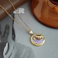 Détail d'un collier vintage doré avec pendentif en émail violet, coquille et perle - Collier Pendentif Coquillage Rond - Violet