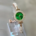 Detailed close-up of a rose gold quartz watch featuring a vibrant emerald green dial - Green