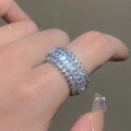 Luxury eternity band ring with baguette cut diamonds and silver finish on finger - White Gold Color