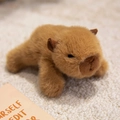 Cute plush capybara refrigerator magnet toy in brown faux fur with a lying posture - Capybara