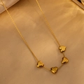 Elegante goldene Halskette mit vier polierten Herzanhängern an einer feinen Kette - Vier Herzen / Gold