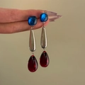 Vintage-Ohrhänger mit blauen Steckern und dunkelroten Acryl-Tropfen in der Hand gehalten - Blau/Silber/Rot (Silbernadel)