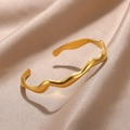 Detalle macro del brazalete ondulado de acero de titanio sobre seda color champán - Estilo Curva de Ola(B1368)