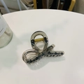 Minimalist translucent smoke grey hair claw clip with golden spring on white surface - Transparent Black