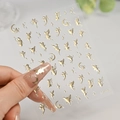 Macro detail of self-adhesive gold nail art decals featuring fairy moon and star designs - C7302 / Champagne Gold