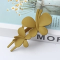 Elegant yellow matte butterfly hair claw clip for bun styling on a white decorative book - Fruit Green