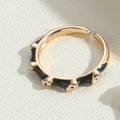 Macro view of gold adjustable ring with black enamel and white evil eye motifs - Adjustable Open / Black