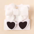 Detail of infant white bow headband and heart-shaped sunglasses set on display card - White Zirconia Set