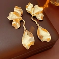 Detailansicht goldener Ohrringe mit Blumenstruktur auf einer braunen Leder-Schmuckschatulle - Gold (925 Sterling Silber Ohrringstift)