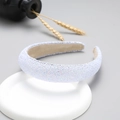 Detail of a wide white headband with a glittery texture on a white round base - White