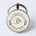 Macro detail of silver alloy keychain with Grandpa and Granddaughter fist bump art - Grandpa & Granddaughter/Best Friends