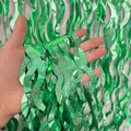 Green wave-shaped metallic foil fringe curtain with shimmering tinsel for party background - Laser S-Shape / Green