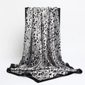 Elegant satin leopard print square scarf in black and white hanging on a display stand - Black Leopard